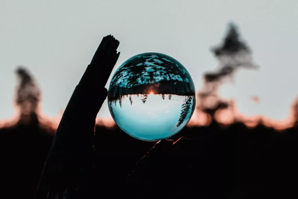 An image of a clear ball reflected the woods upside down at sunset. featured image for the sapir-whorf hypothesis article.