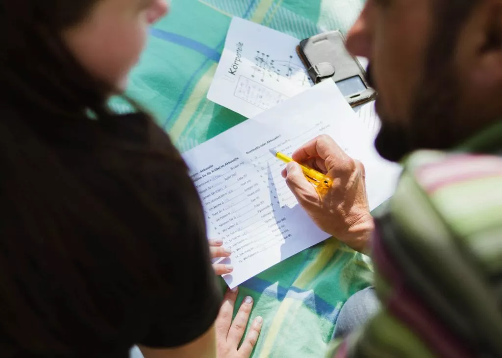 An image of a man and a woman discussing a language learning exercise...maybe going over a difference in language style?